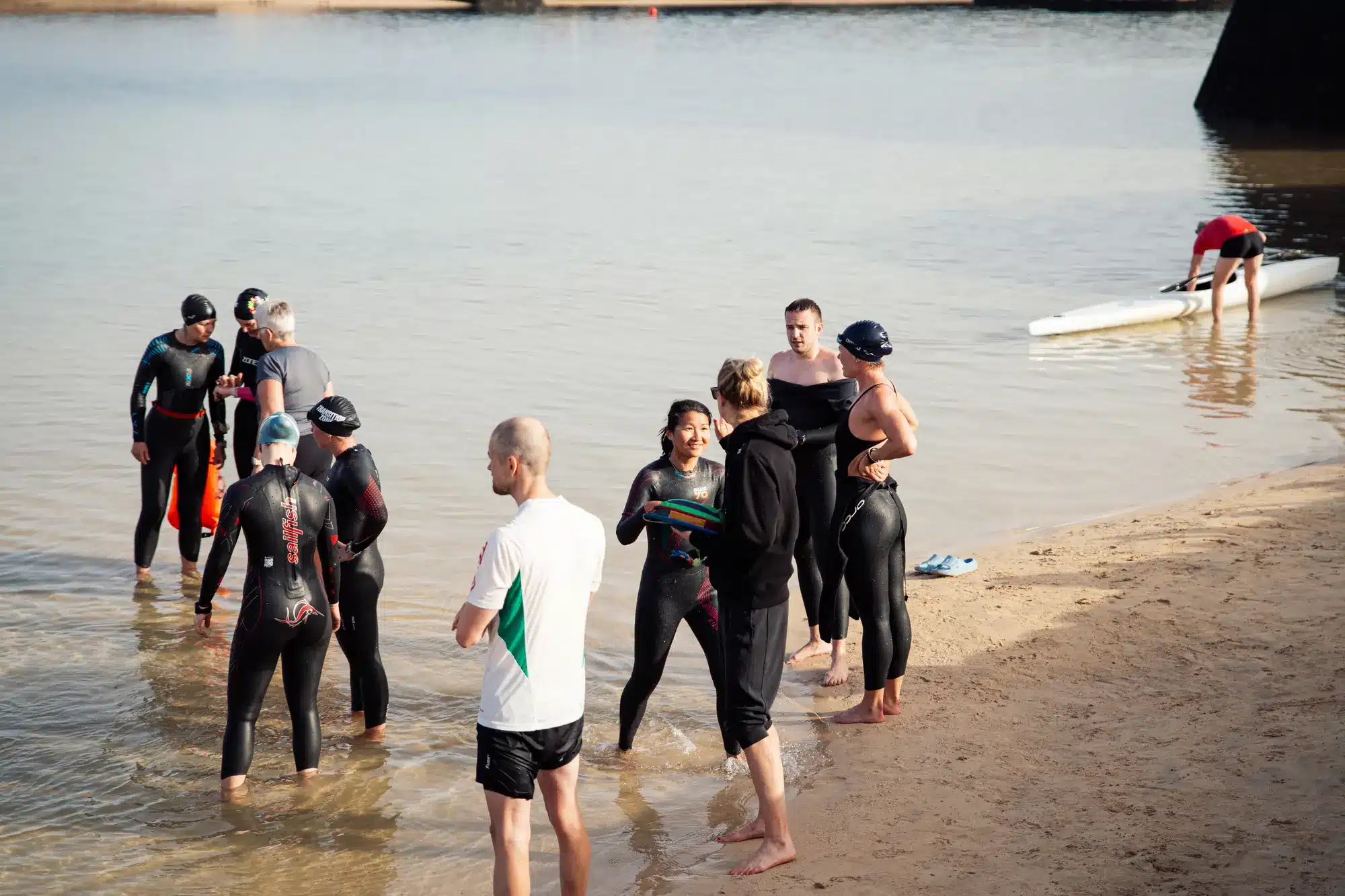 Laktattest til triatlon – triatleter i våddragt - Coach Lykke Endurance Laktattest til triatlon: triatleter i våddragt samles i vandkanten før svømmetræning i åbent vand