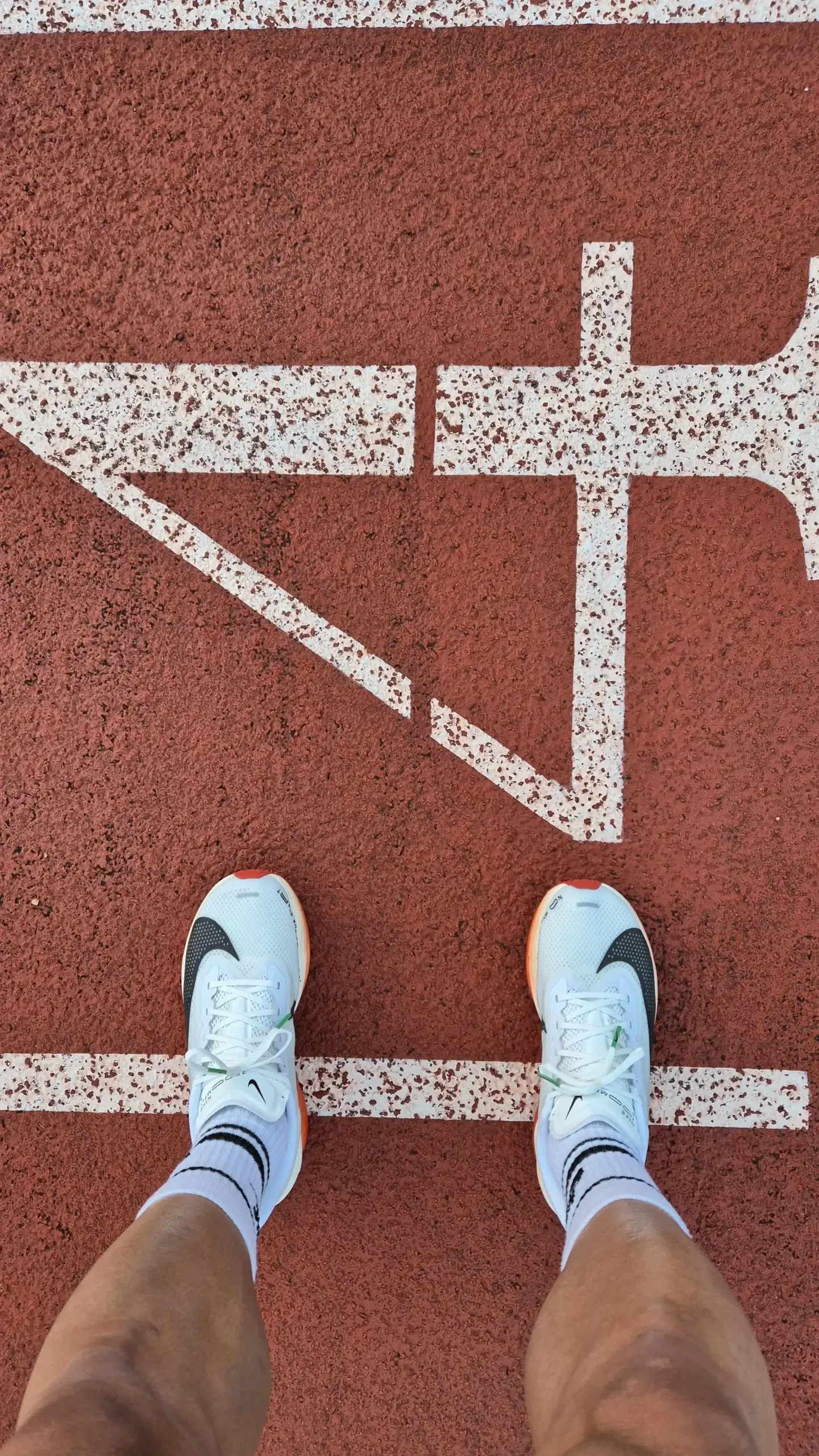 Løbezoner: løber ved startlinjen - Coach Lykke Endurance Løbesko ved startlinjen på en atletikbane – find dine løbezoner med en test