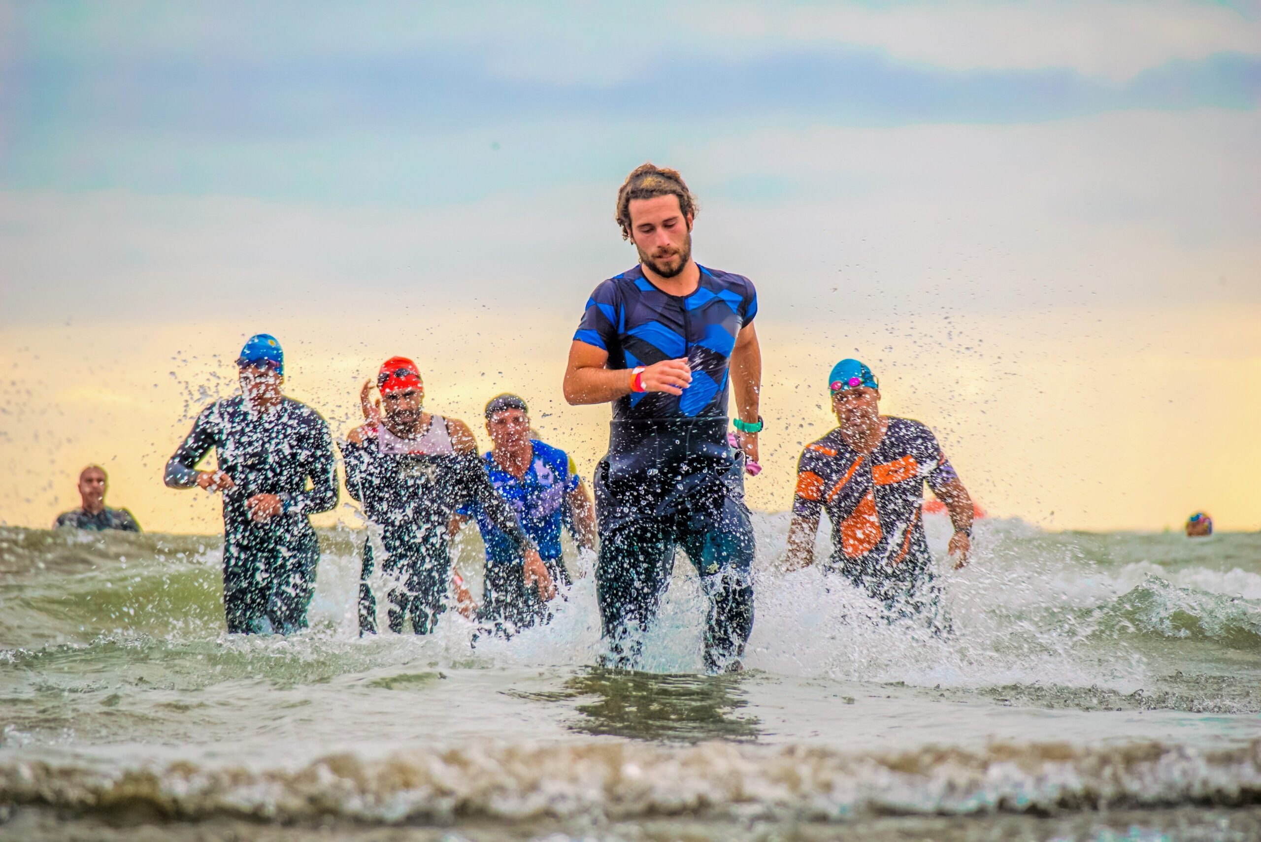 Triatleter løber op af havet efter svømningen ved sprint triatlon - Coach Lykke Endurance Sprint triatlon: triatleter løber op af havet efter svømningen