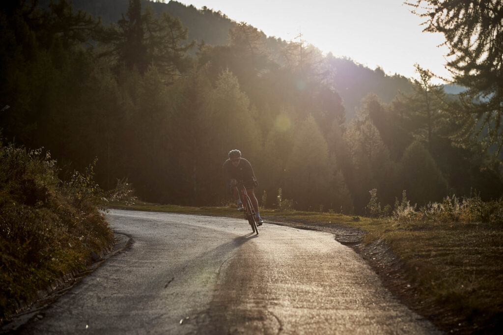 Kontaktformular med baggrundsbillede af cykelrytter i træning på en solbeskinnet bjergvej – ideel til personlig cykeltræning.