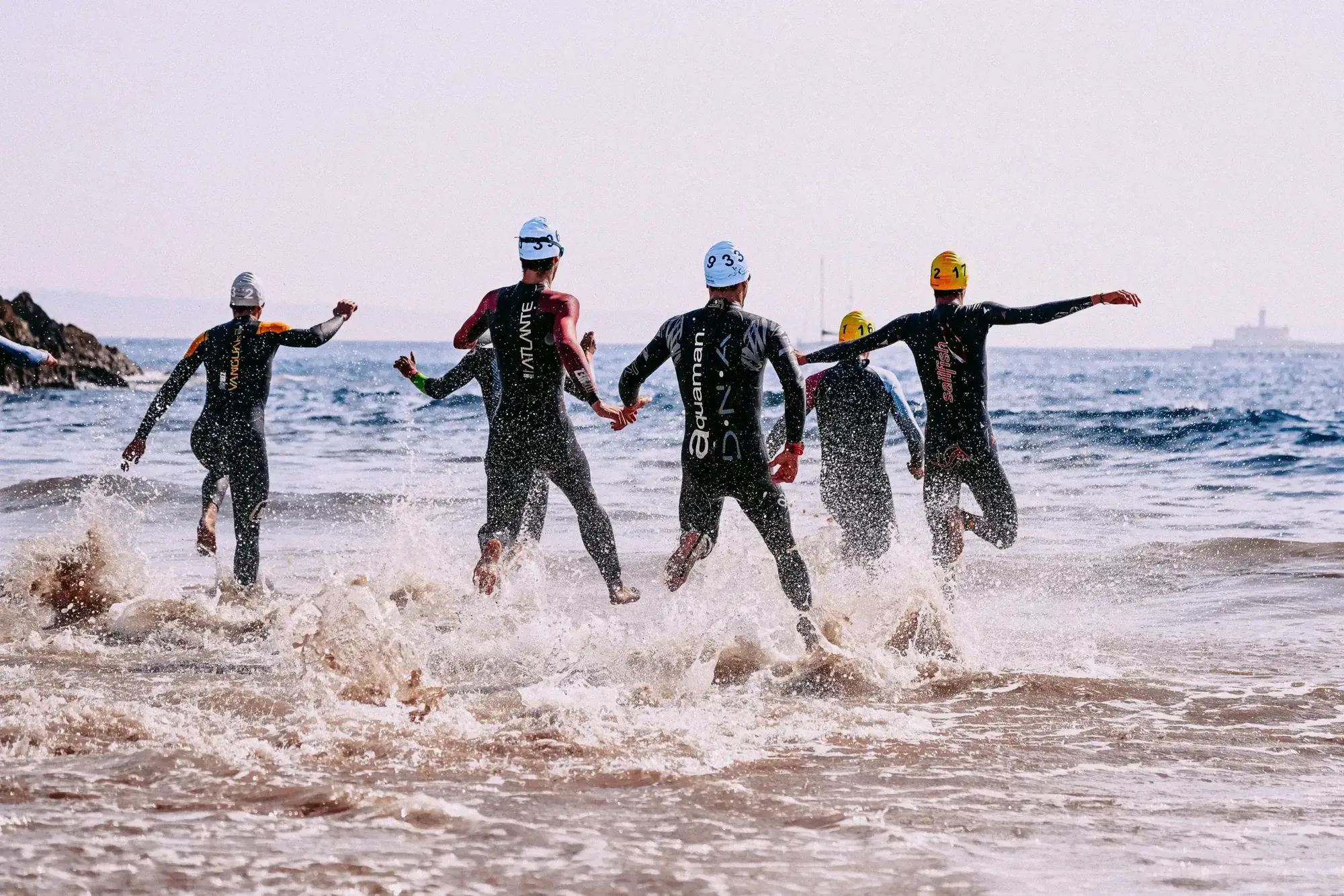 Tjekliste svømning: triatleter løber ud i vandet - Coach Lykke Endurance Triatlon og Ironman tjekliste til svømning – husk våddragt, svømmebriller og skiftetøj til konkurrencen.