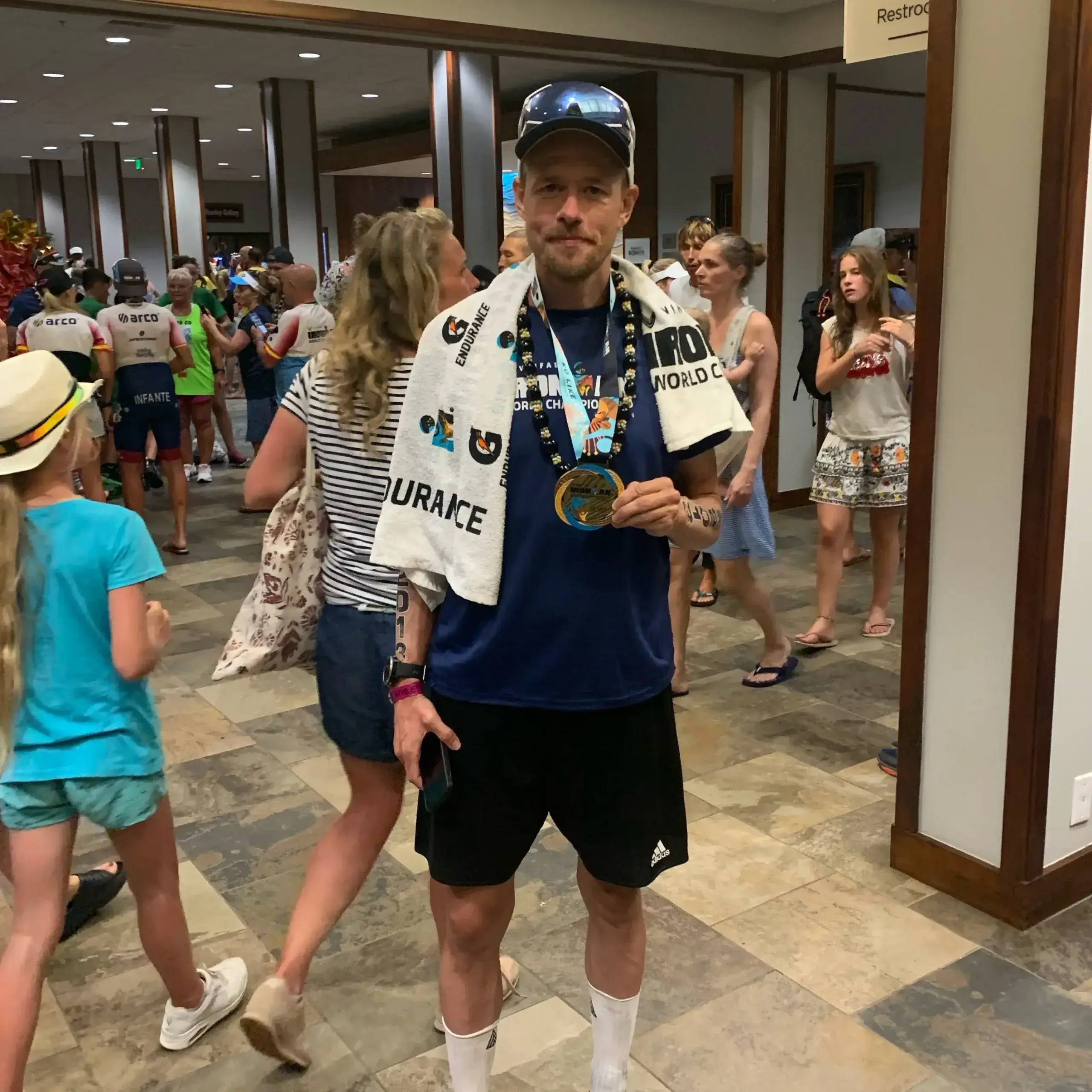 Coach modtager medalje efter triathlon-konkurrence – symbol på coaching og personlig succes.