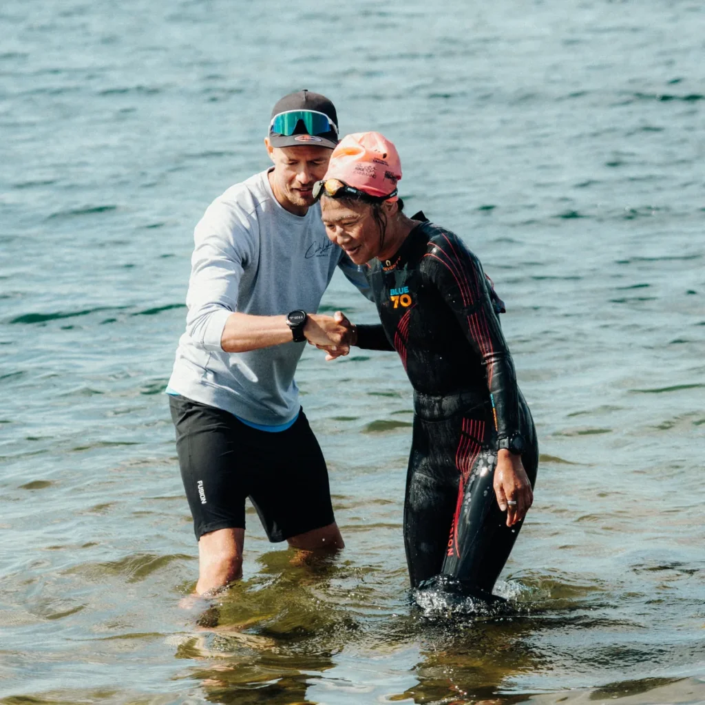 Open water-træning med Thomas Lykke Sørensen - Coach Lykke Endurance Thomas Lykke Sørensen hjælper en atlet op af vandet under open water-træning